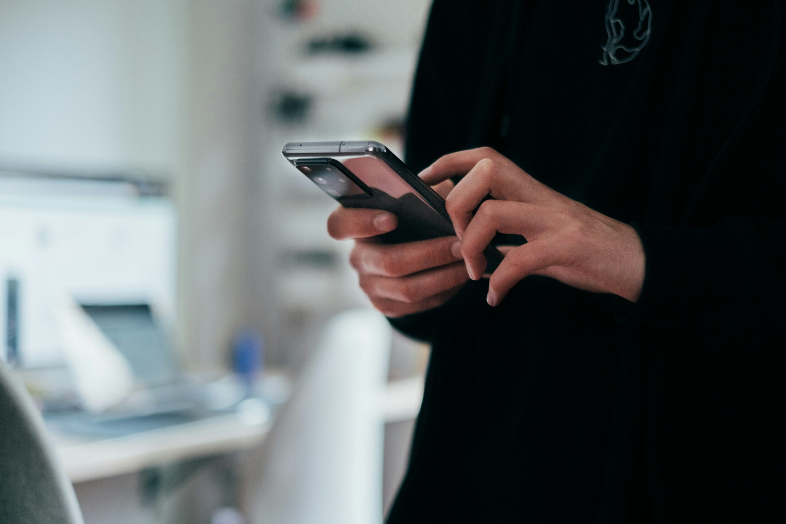 Close-up of a person using a smartphone powered by a business data SIM for temporary internet connectivity.